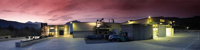 illuminated 'Vassilakis Estate' building olive oil plant outside by night
